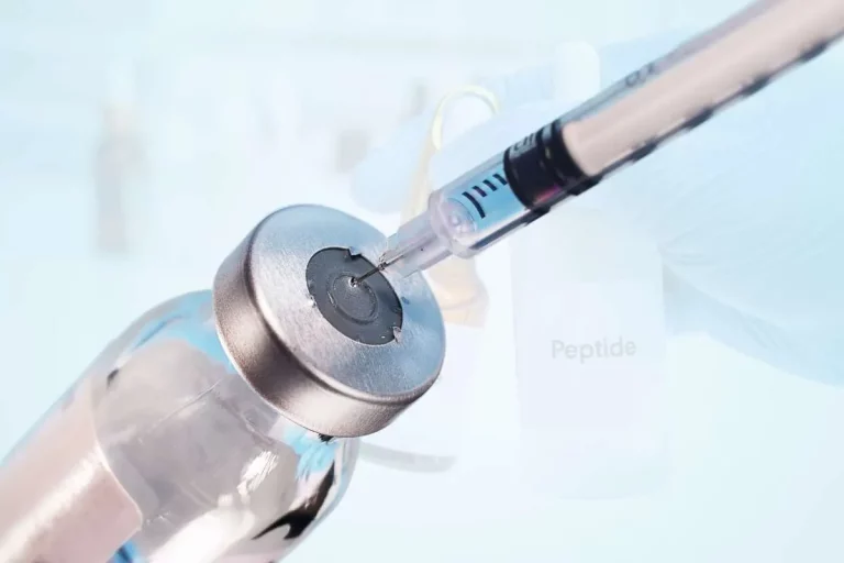 A syringe with its needle on a jar of Peptide.
