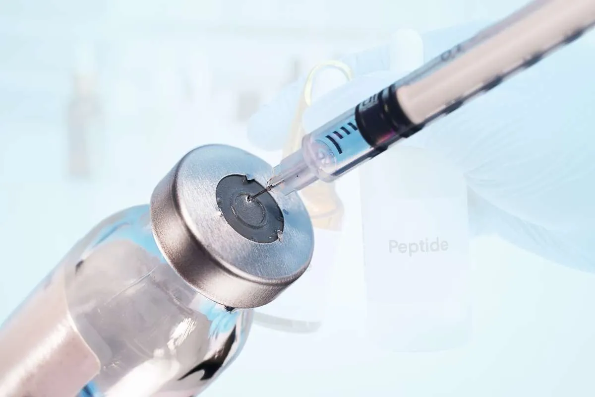 A syringe with its needle on a jar of Peptide.